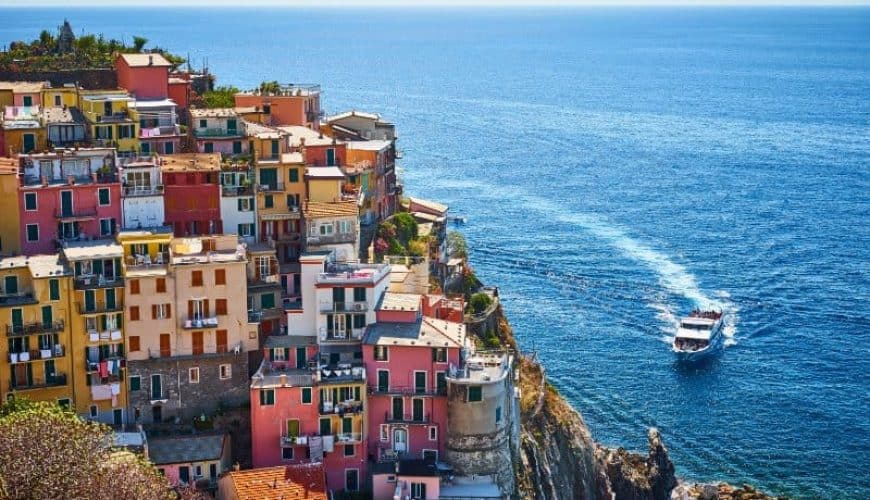Ferry arriving at colorful ligurian town in Italy