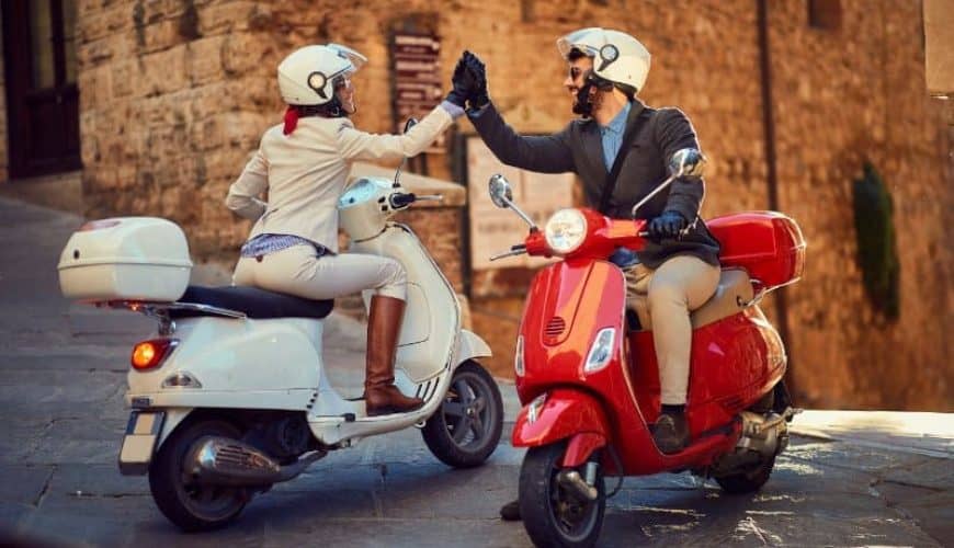Young Couple on Vespa Scooter greeting each other