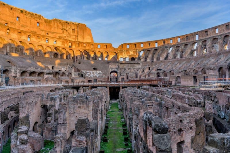 sunset view of the arena and hypogeum surrounded by ancient high walls at inside of the Colosseum