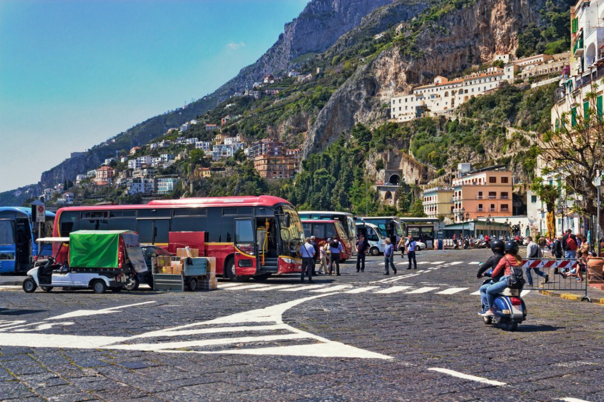 Row of buses parked along the side of a scenic street on the Amalfi Coast