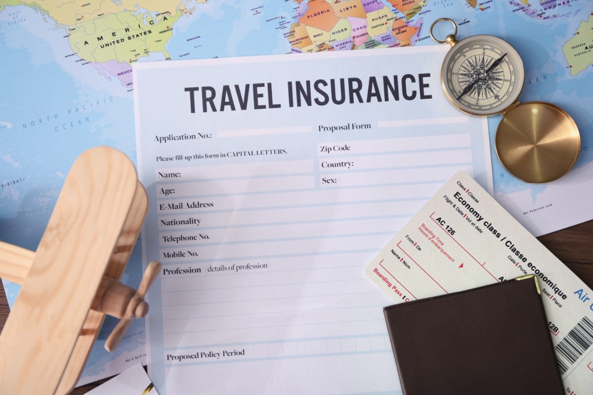 Blank travel insurance form next to a plane ticket and passport