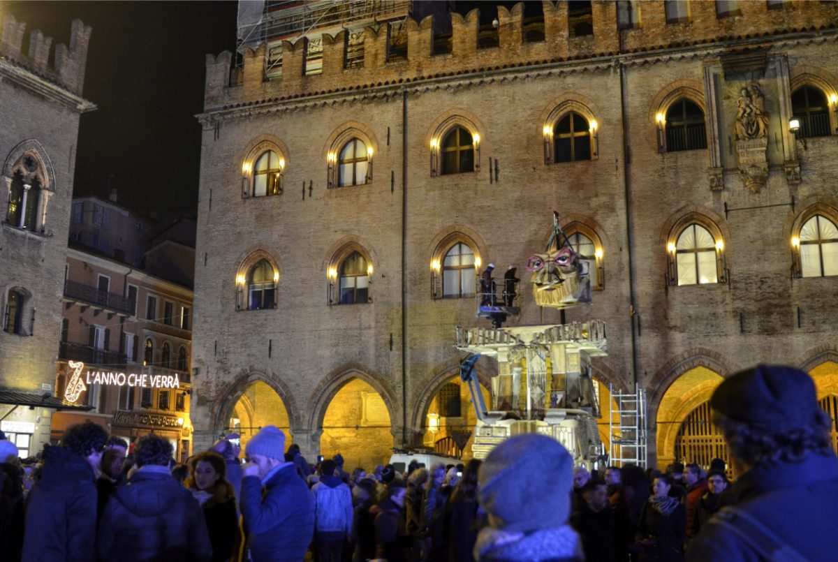 Tourists and locals walking and exploring in front of the Palazzo Re Enzo in Bologna, Italy 