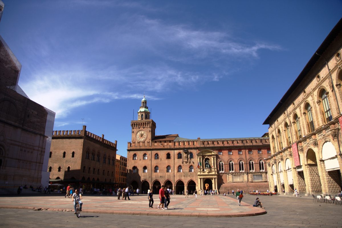 Tourists and locals exploring the Piazza Maggiore in Bologna, Italy