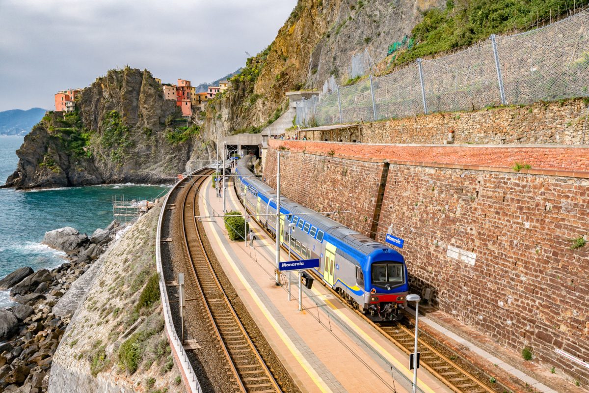 Train passing through Manarola railway station, part of the Cinque Terre Railway in Manarola, Italy