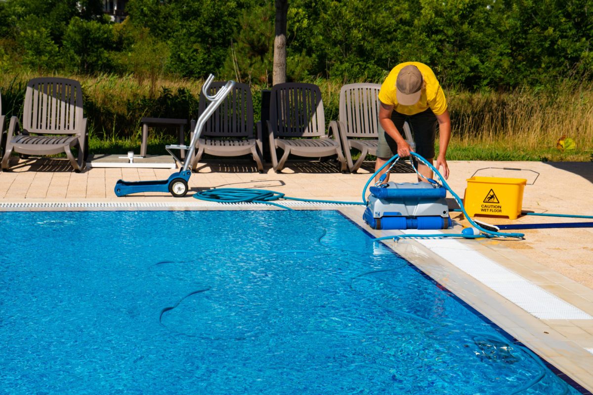 Man cleaning the pool with a pool cleaning device