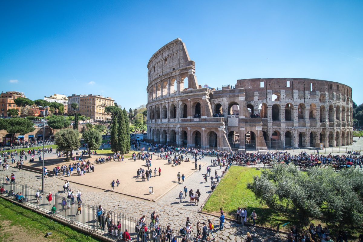 Panoramic view of the Colosseum with tourists exploring the iconic landmark in Rome, Italy