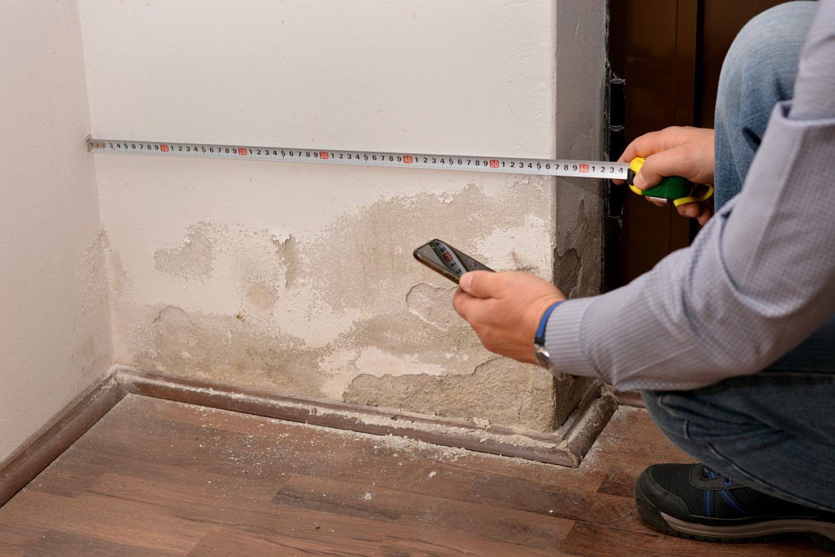 Man checking out a damaged walls