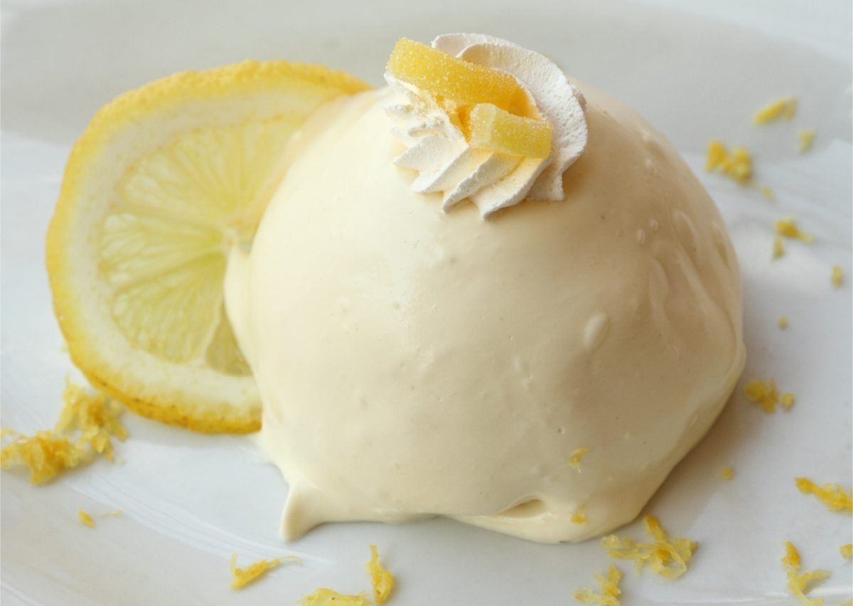 Close-up of a Lemon delight or the Delizia al limone served on a white plate with a slice of lemon