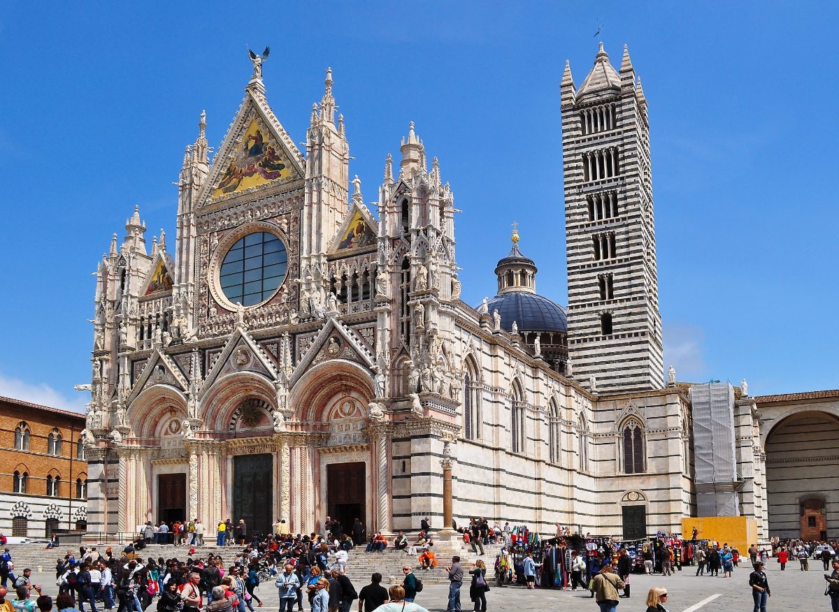 Tourists and locals exploring the Duomo di Siena or the Siena Cathedral in Siena, Italy