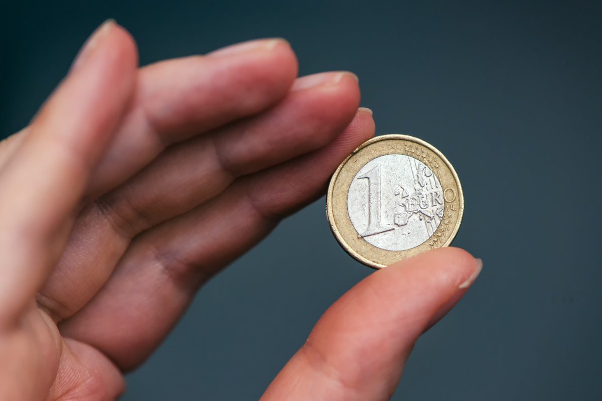 Close-up of holding one euro coin 