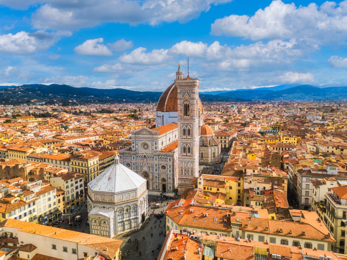 Aerial view of Florence, Italy, showcasing a stunning church surrounded by the city's iconic rooftops and vibrant cityscape