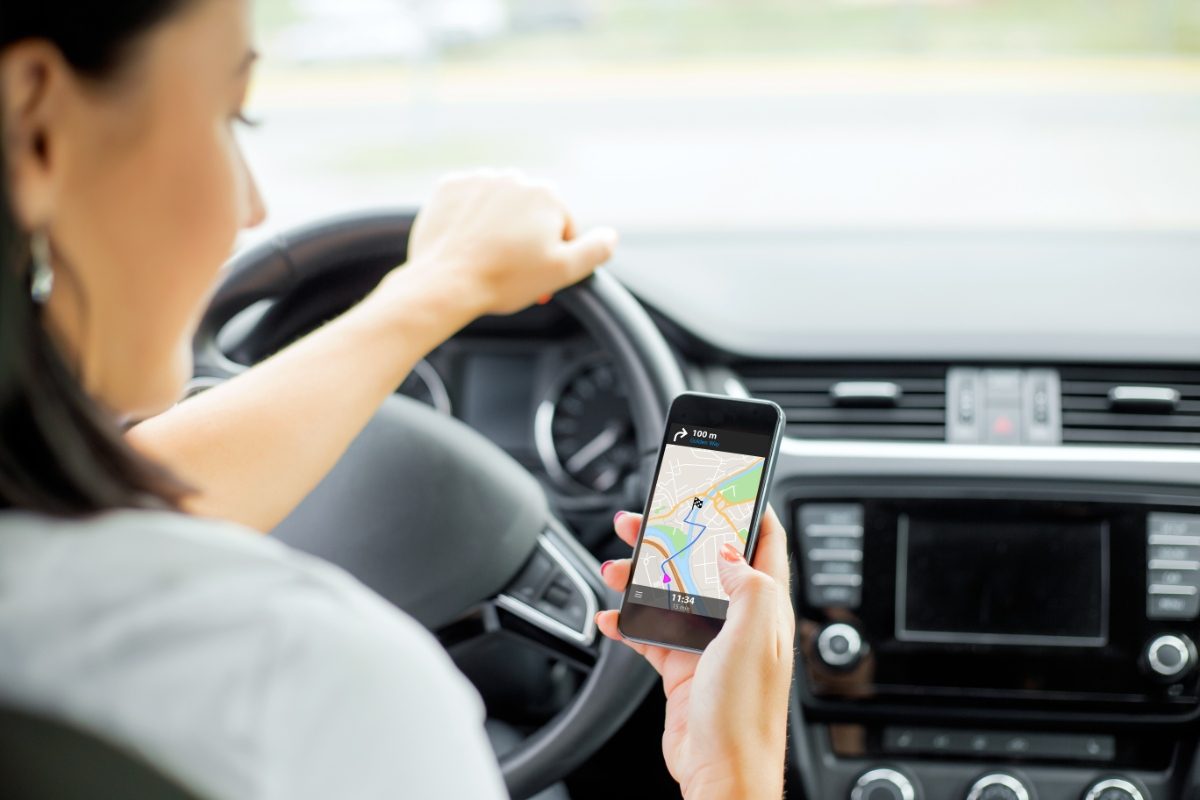 Driver using GPS map navigation app on mobile phone