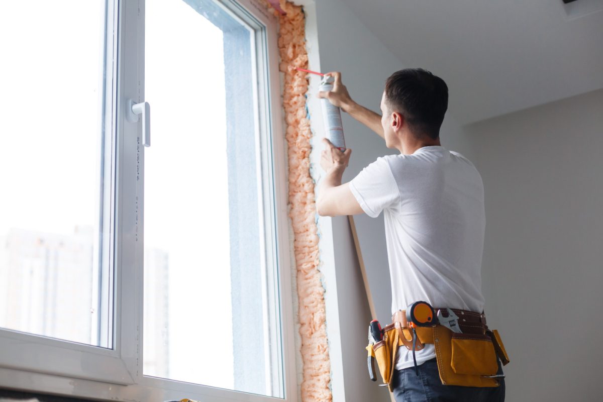 Man doing a maintenance and repairs between window and wall