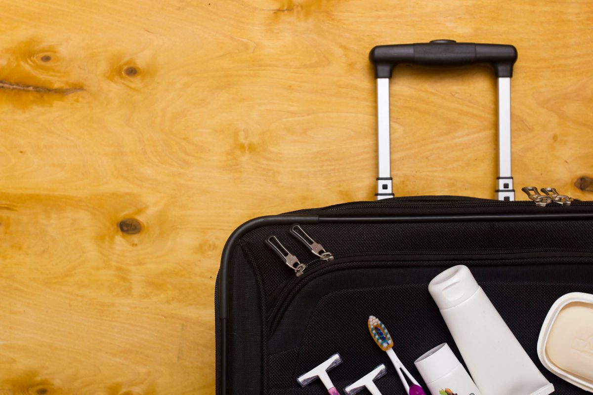 Top view of skincare and hygiene products  on top of a suitcase