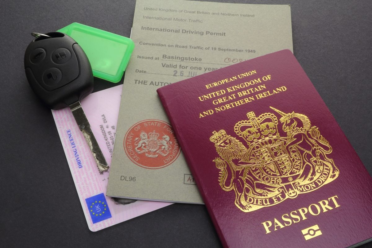 Passport placed next to an International Driving Permit, a driver’s license, and a car key