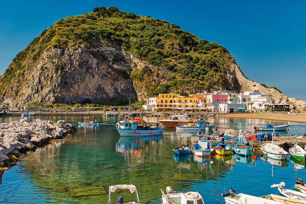 Panoramic view of boats and houses at the bay of Ischia Island, Italy