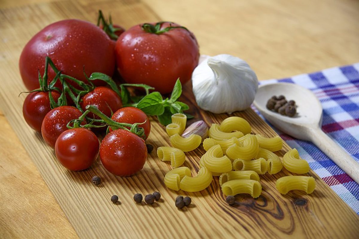 A mouthwatering array of traditional Italian dishes, including pasta, pizza, bruschetta, and antipasto, arranged beautifully on a rustic wooden table.