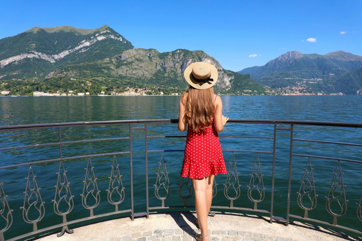 Young woman Lake Como tourist wearing a hat and a red dress