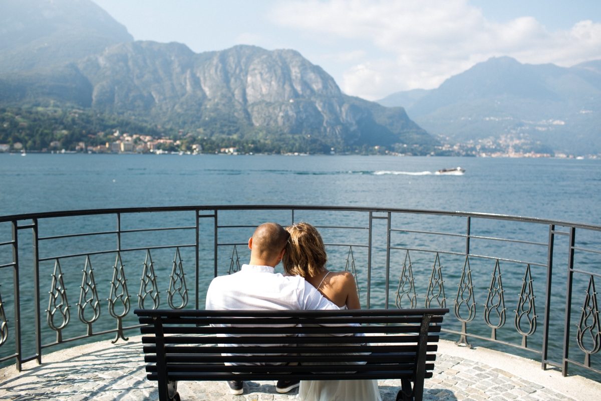 Bride and groom hugging on a terrace overlooking Lake Como, Italy