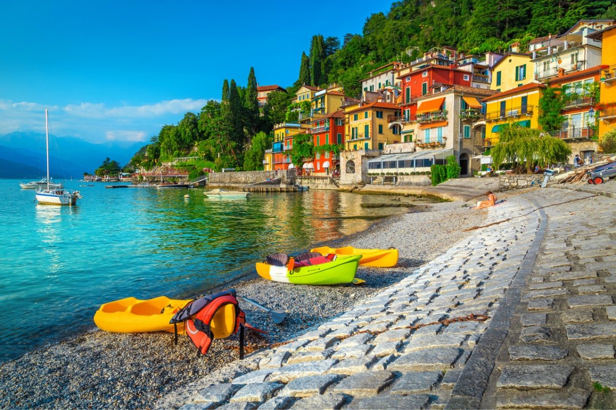 Panoramic view of the town of Varenna with kayaks resting along the shores of Lake Como