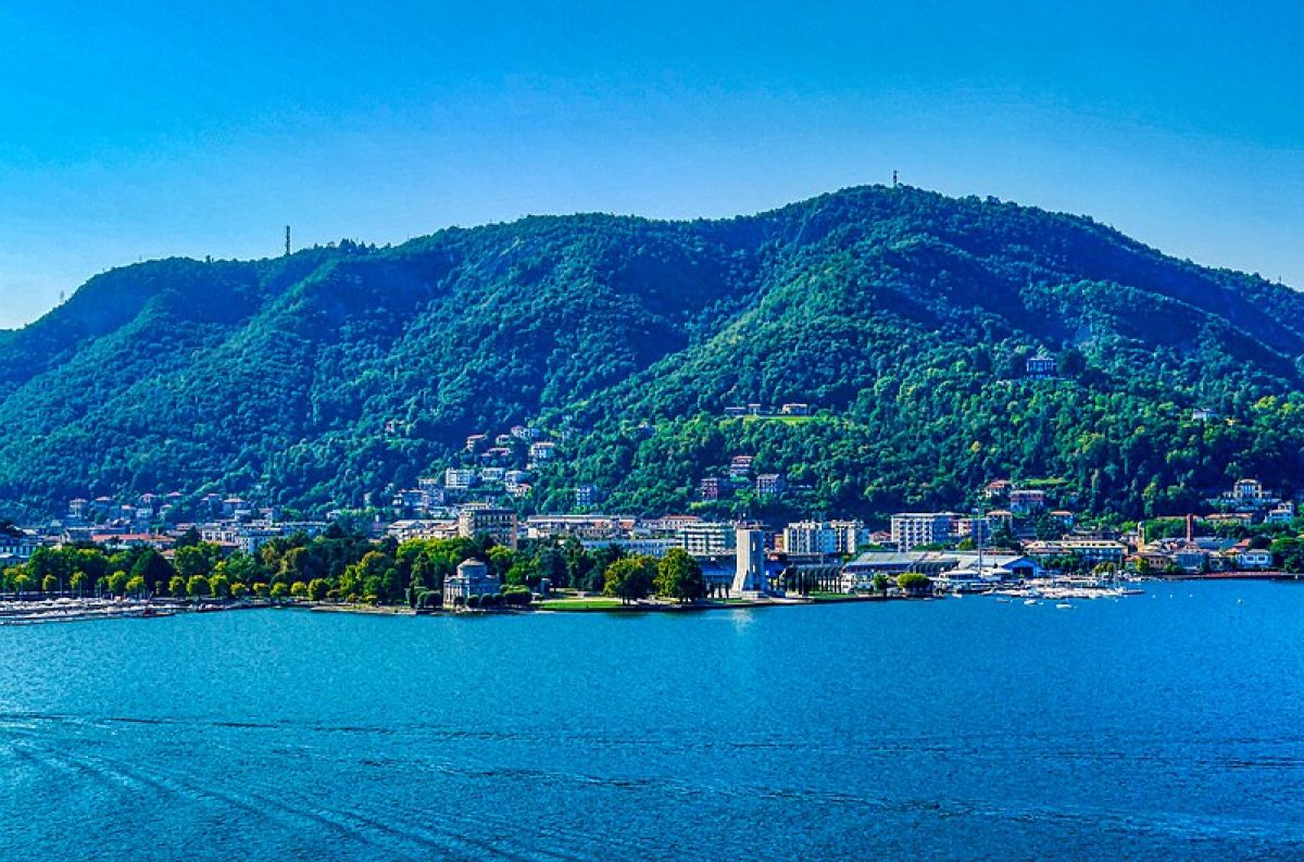 A breathtaking view of one of the picturesque islands on Lake Como, Italy, surrounded by shimmering blue waters and lush greenery.