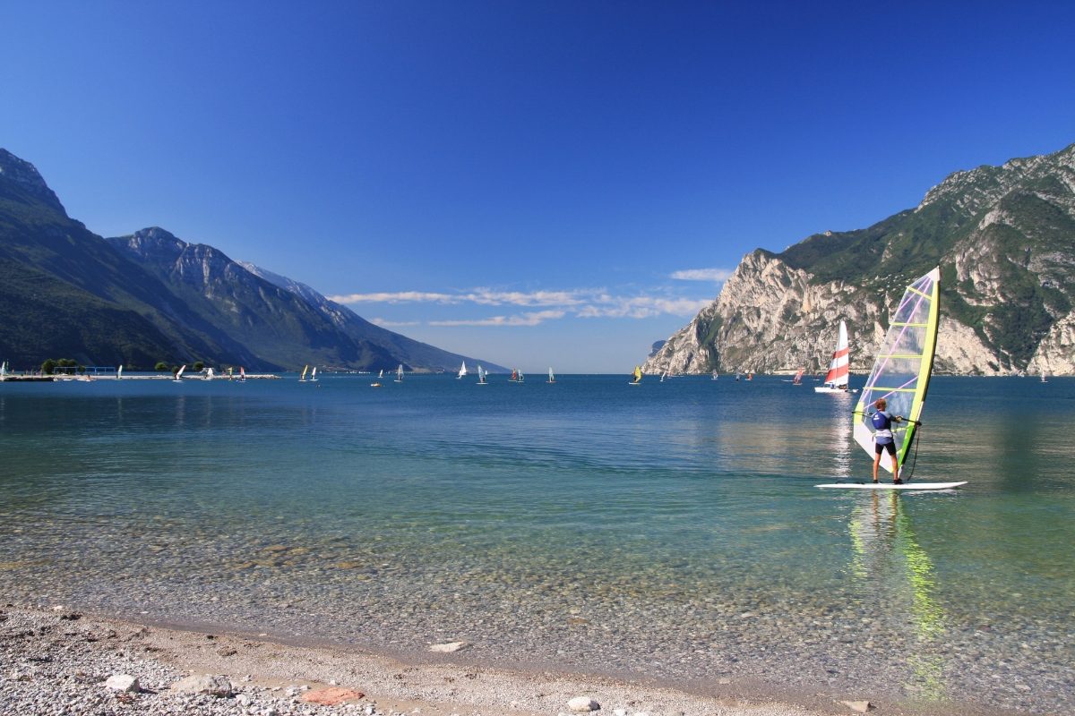 Windsurfers glide across the sparkling waters of Lake Garda in Italy