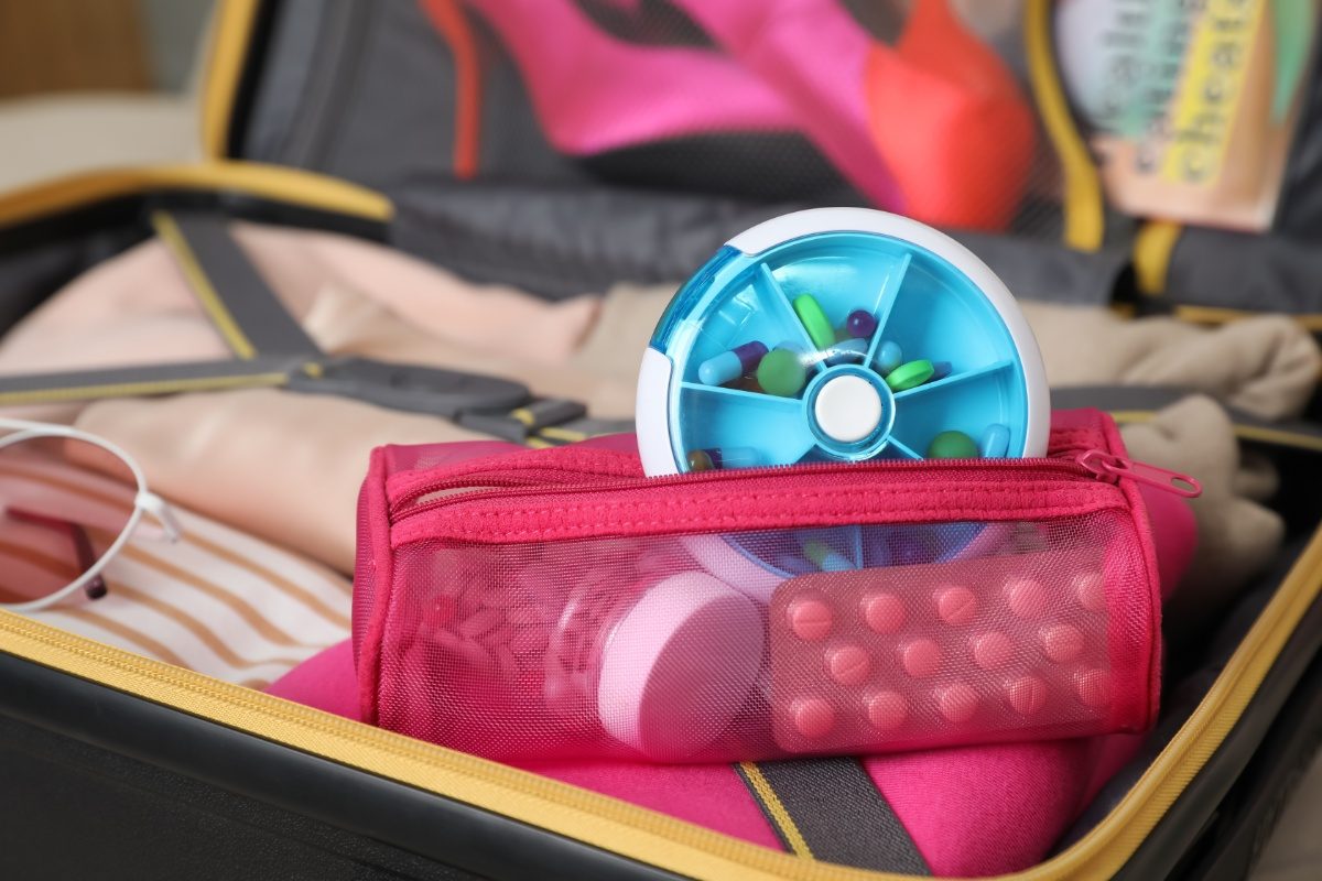 Close-up of a pouch containing various medications and a pill box, neatly organized for easy access while traveling