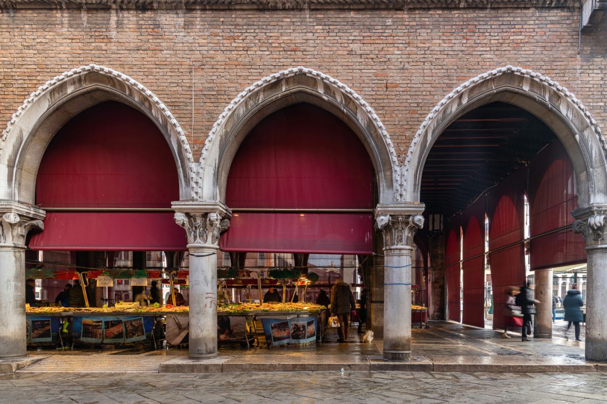 Market stalls, sellers, and shoppers at Mercato di Rialto in Venice, Italy