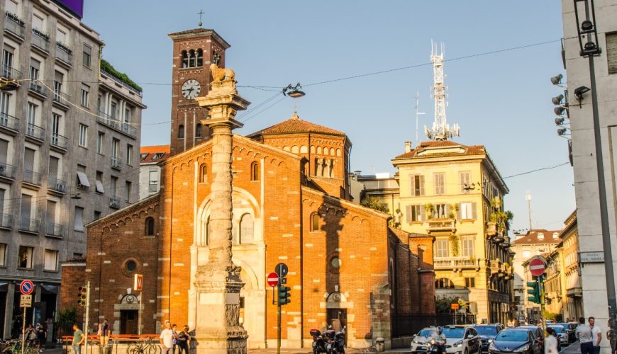 Traffic and different vehicles next to the Basilica di San Babila church in Milan, Italy