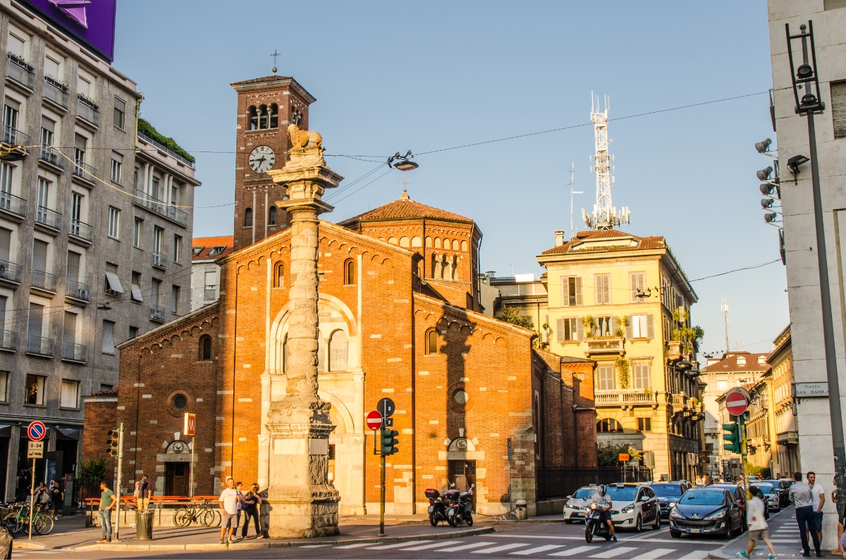 Traffic and different vehicles next to the Basilica di San Babila church in Milan, Italy