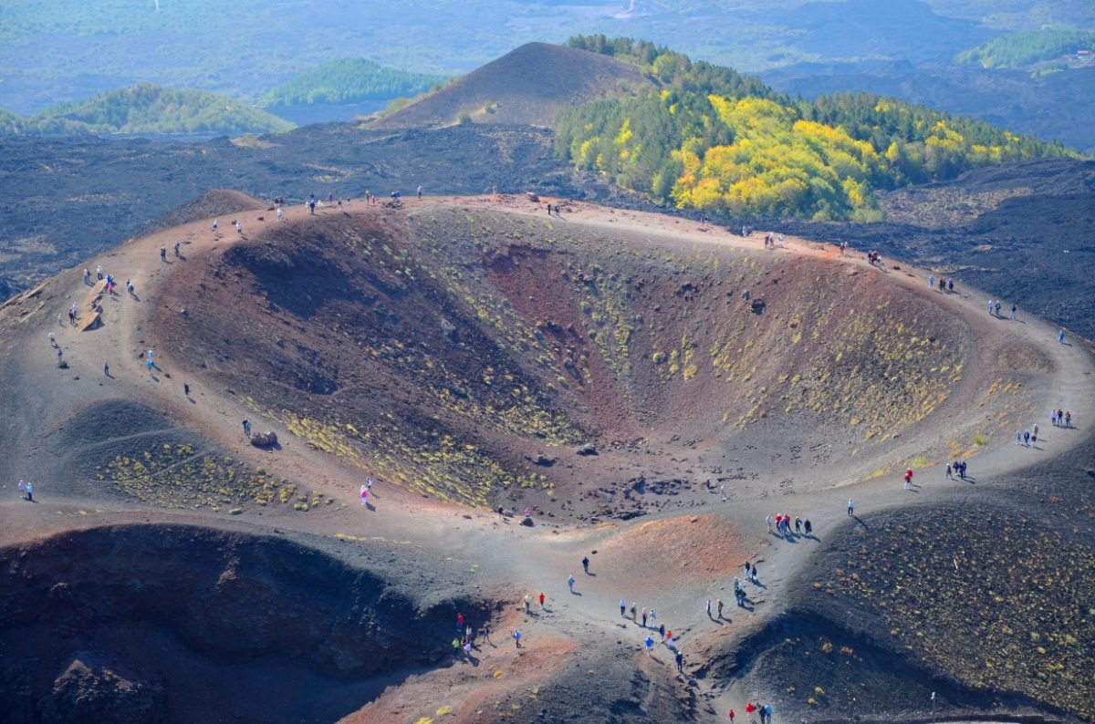 Group of tourists hiking the Mount Etna volcanic crater in Sicily, Italy