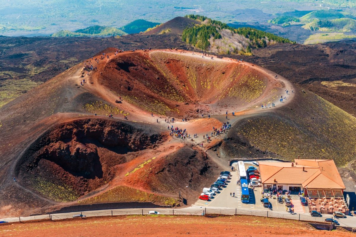 Group of tourists exploring the Mount Etna volcanic crater in Sicily, Italy