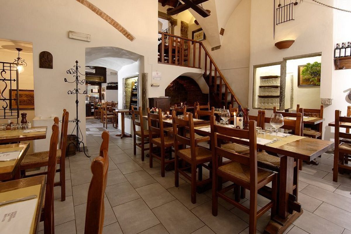 Room interior and dining tables at Osteria del Cinghiale Bianco in Florence, Italy