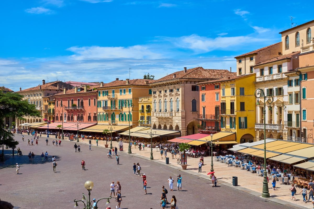 Panoramic view of locals and tourists exploring the cafés, restaurants, and shops at Piazza Bra in Verona, Italy