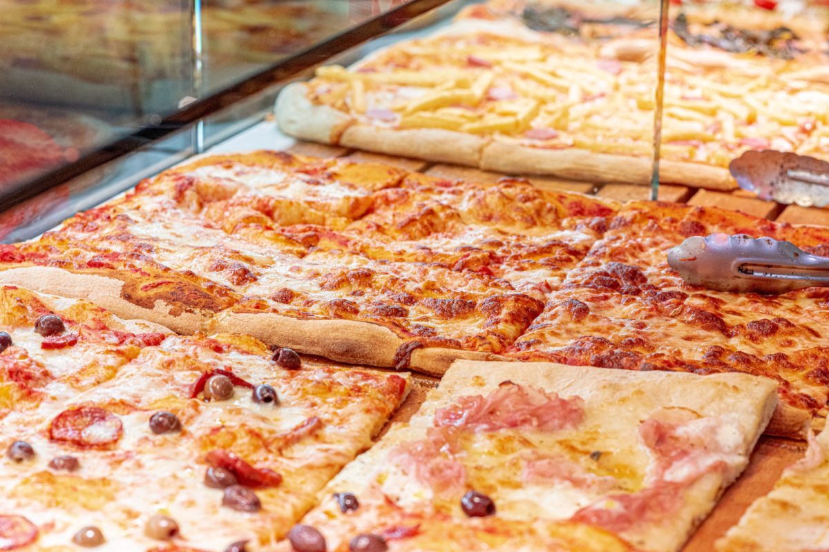 Close up of Pizza al Taglio or pizza by the slice with different toppings