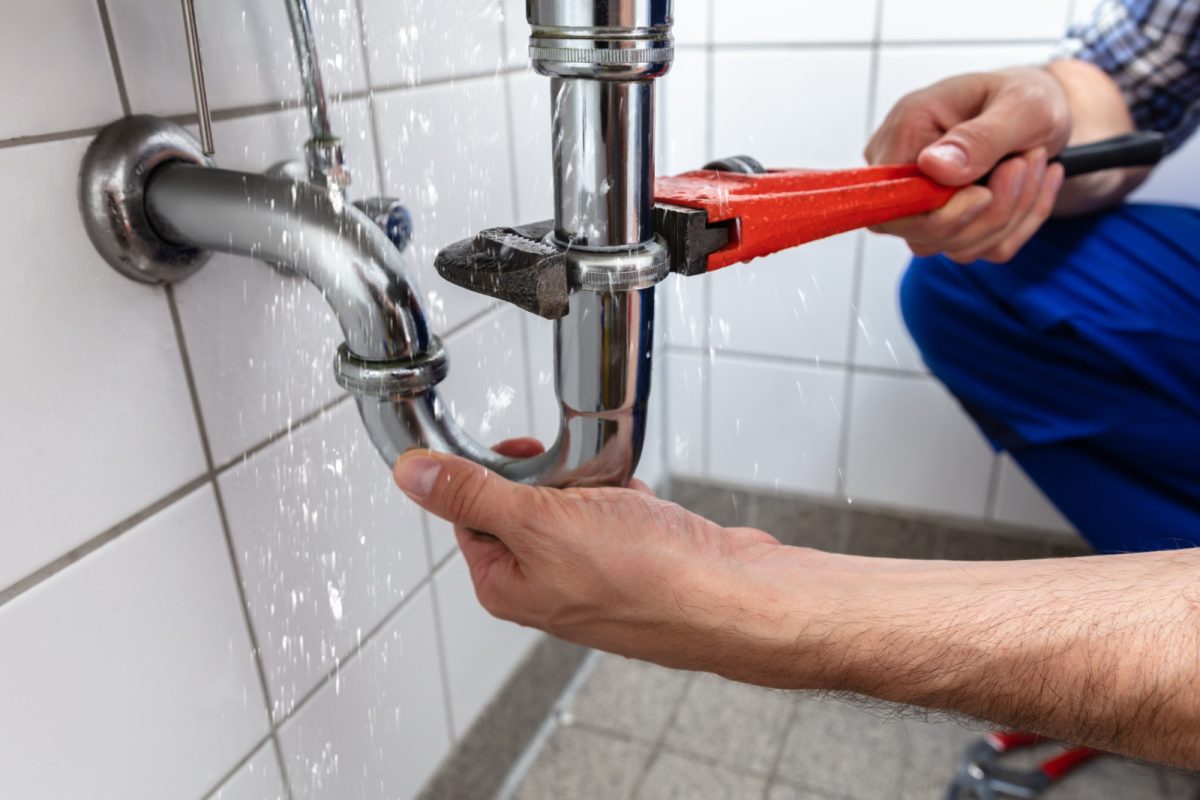 Plumber repairing a broken sink leakage