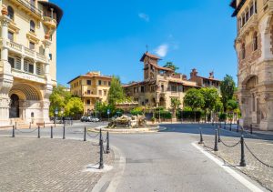 Panoramic view of a fountain and historic buildings in the Quartiere Coppedè in Rome, Italy