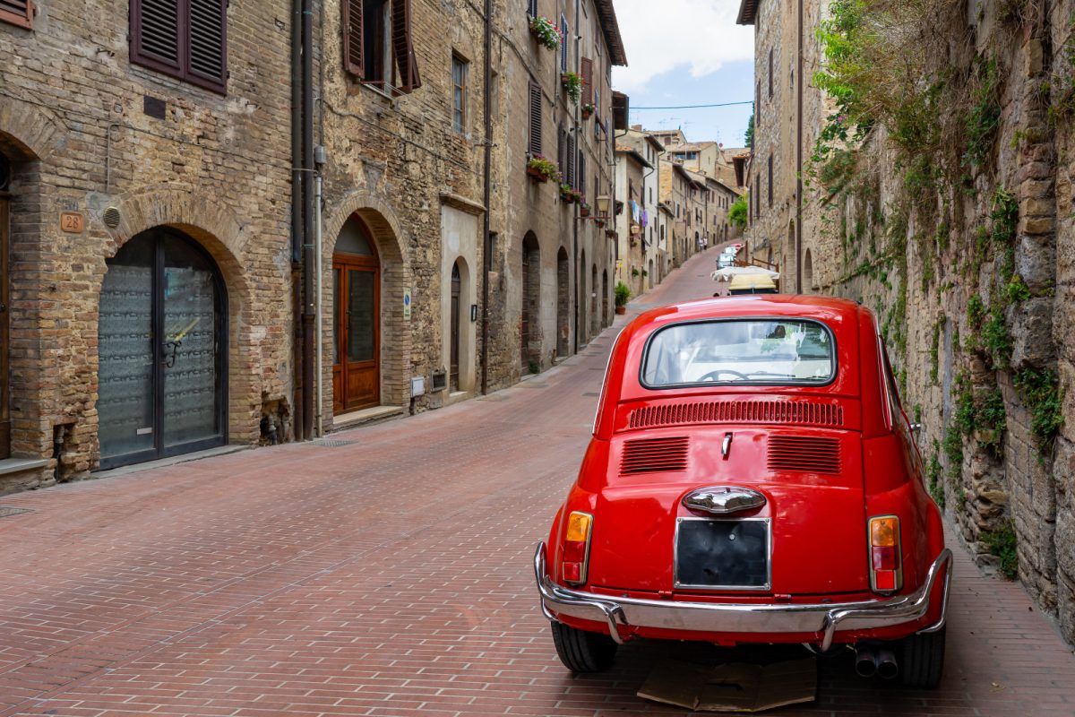 Red Car park on a cobbled street in Tuscany, Italy