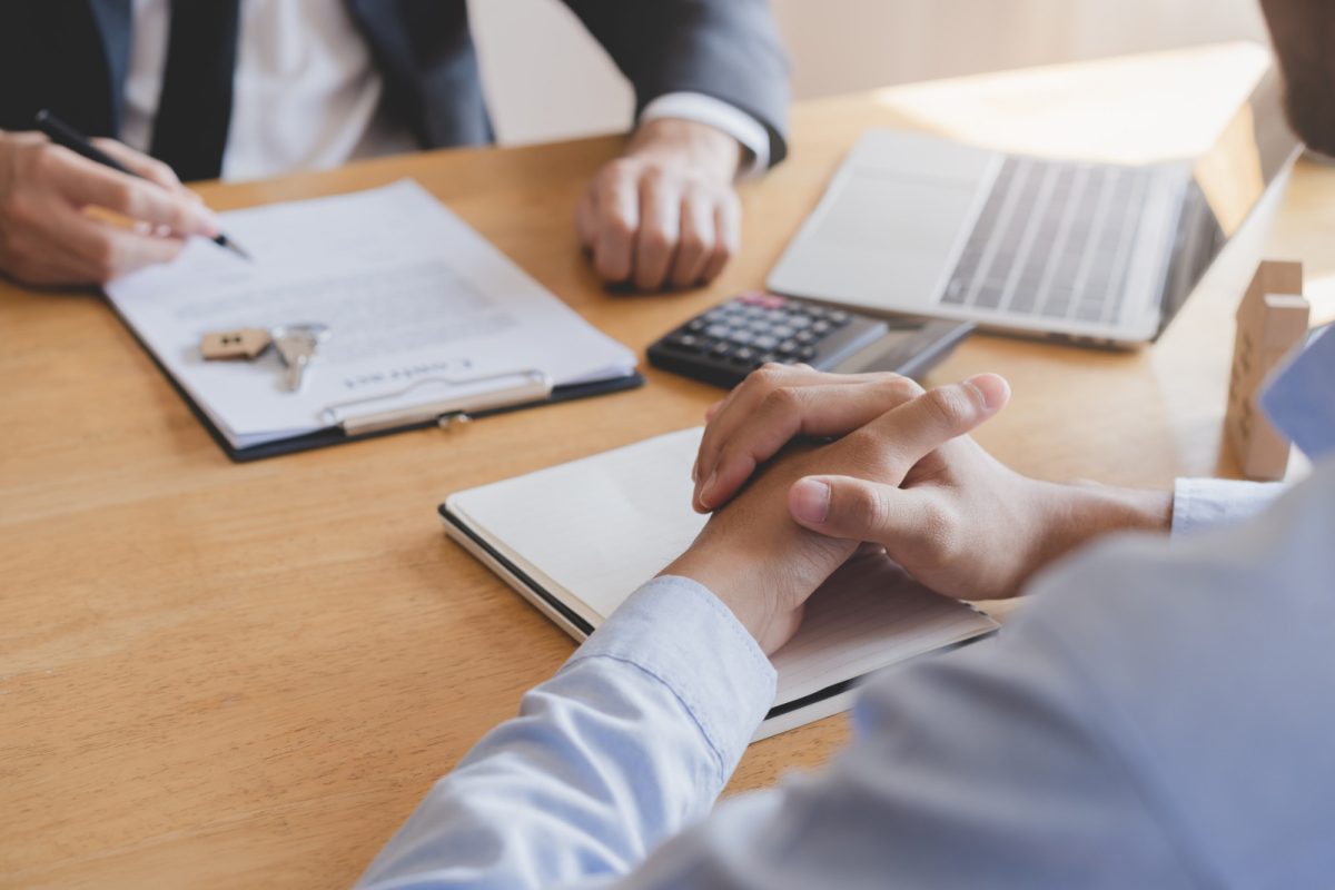 Two people discussing rental agreement and signing papers