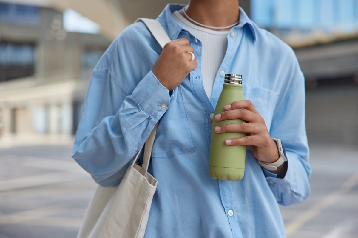 Woman holding an open reusable water bottle