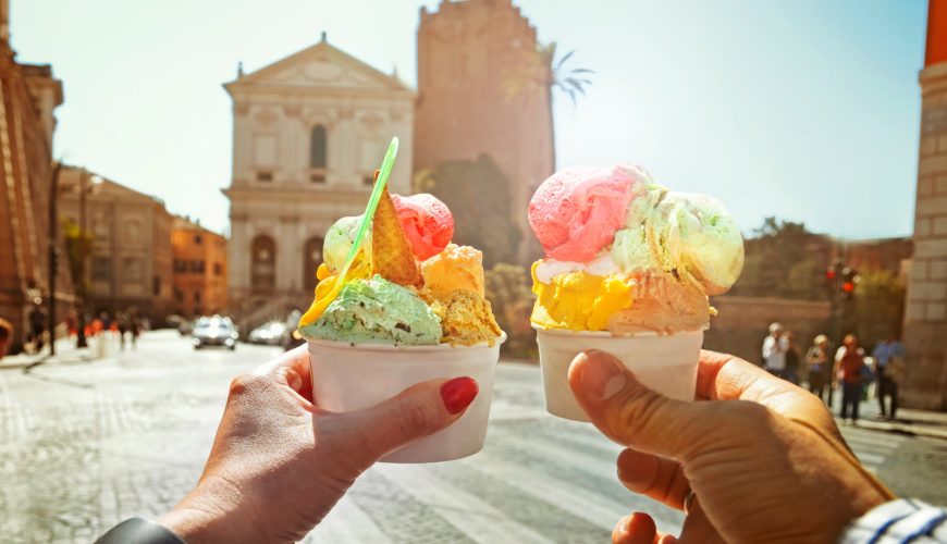 Couple holding cups of gelato in Rome, Italy