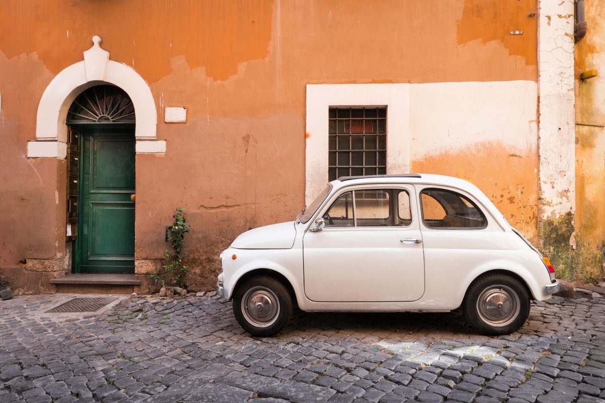 Vintage white car parked on a street in Rome, Italy