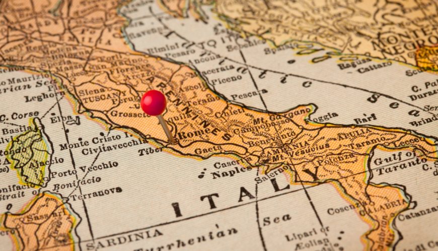 Close-up of a pin marking Rome on a vintage map of Italy