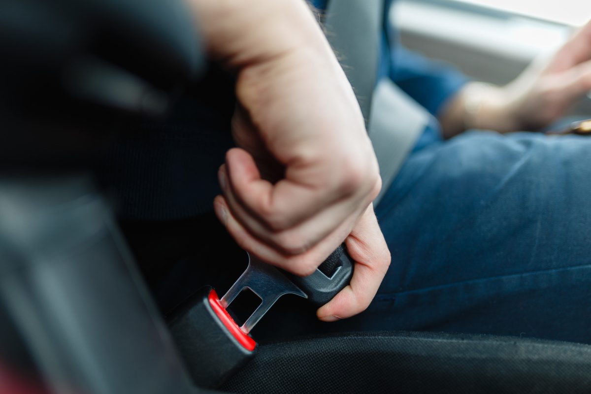 Close-up of a man putting on a seatbelt