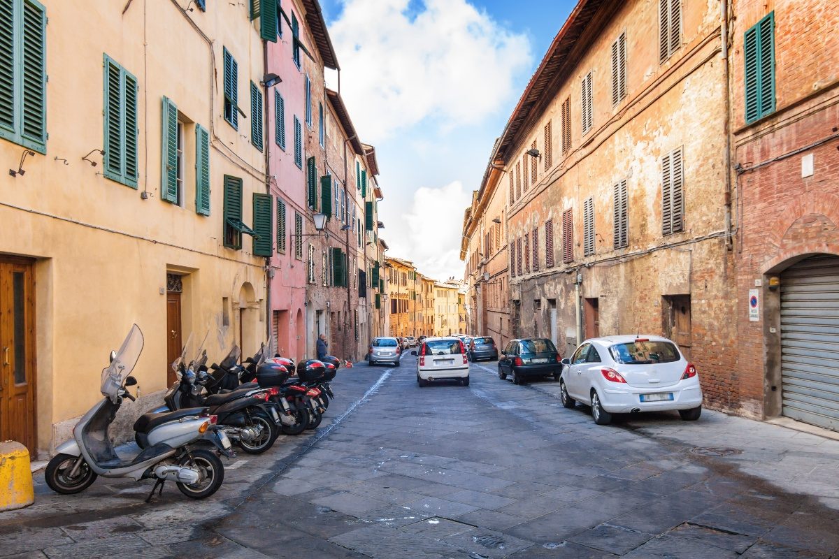 Parked cars on a street of downtown Siena, Italy