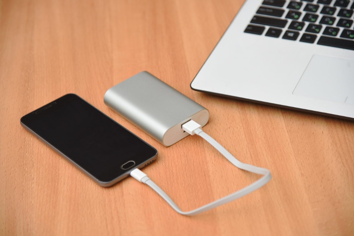 Laptop and a smart phone connected to a portable charger power bank