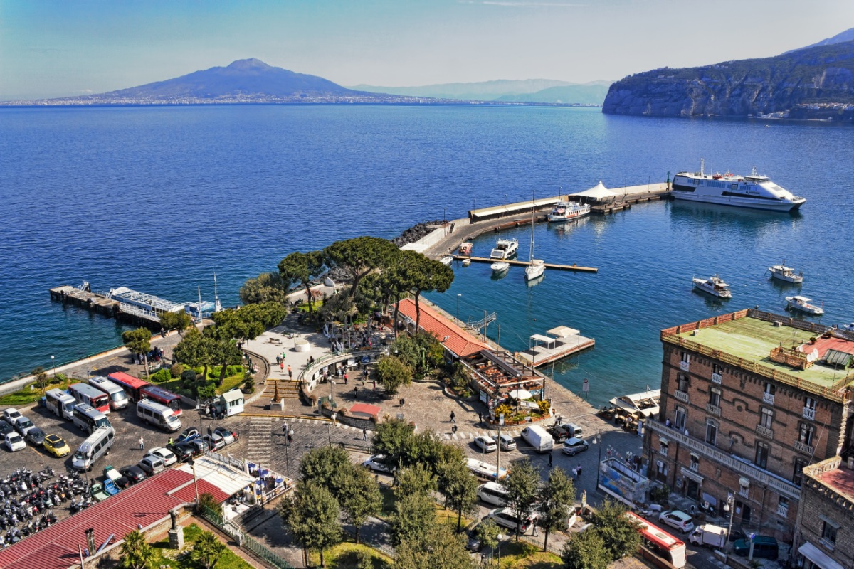 Aerial view of a port with parked cars and various vehicles in Sorrento, Italy