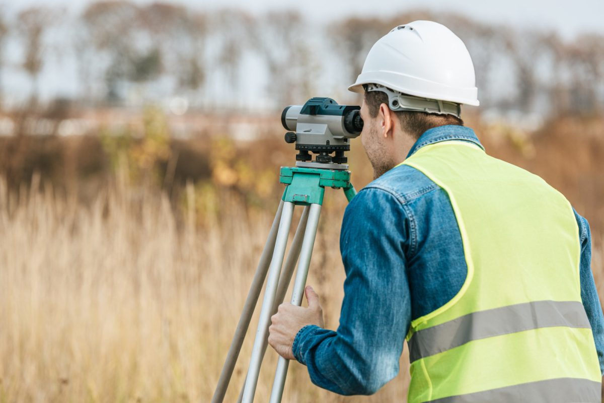 A man surveyor looking through digital level device