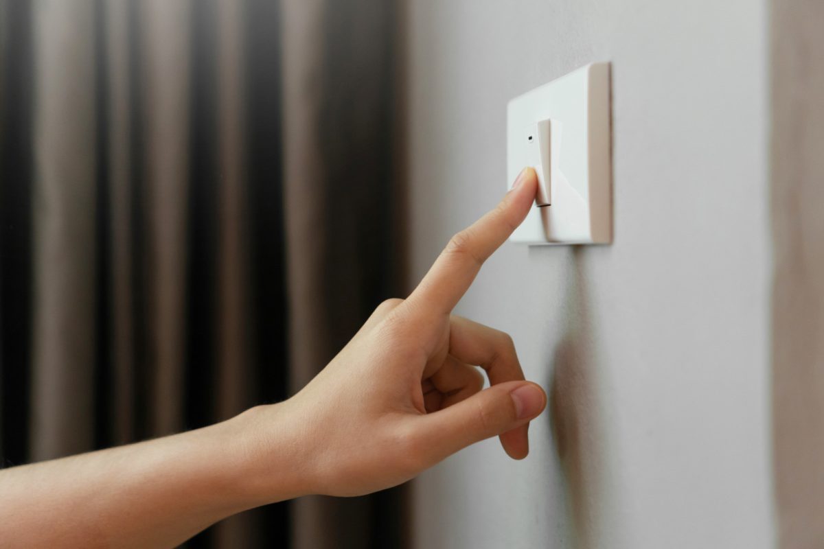 Finger turning off the light switch