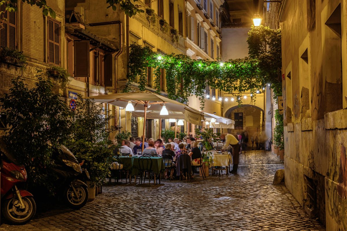 People eating at a restaurant by the street in Trastevere in Rome, Italy